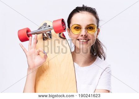 Woman with longboard in hands, woman and skateboard in studio.