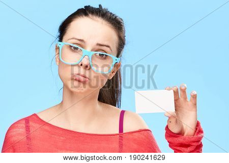 Woman with bright background. A woman with a white blank business card in her hands.