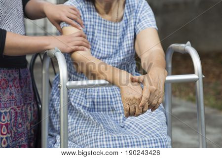 Elderly physical therapy by caregiver in backyard at home.