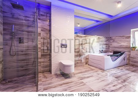 Bathroom With Marble Tiles And Glass Shower Cabin