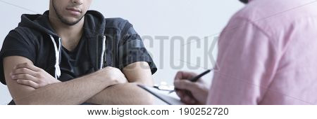   abused teen boy having conversation with psychotherapist