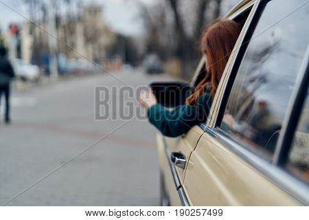 Beautiful young woman in the car, a woman is riding in a retro car.