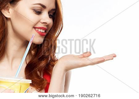 Woman with cooling drink on isolated background, red-haired woman drinking.