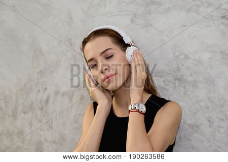 Beautiful young woman enjoying music at home.