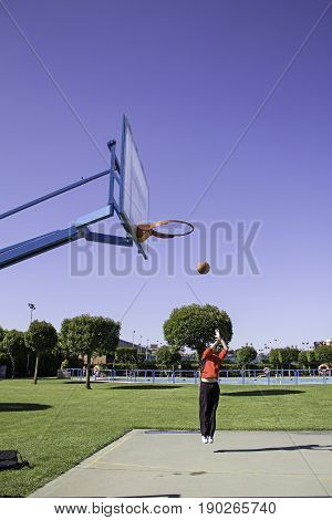Young playing basketball sports center  in city
