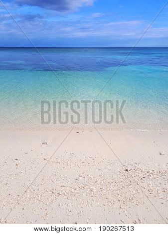 White clouds on blue sky over calm sea. Clear blue water with fantastic white sand beach. Summer outdoor nature holiday serenity. Kalanggaman Island Philippines.
