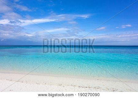 White clouds with blue sky over calm sea. Clear blue water with fantastic white sand beach. Summer outdoor nature holiday serenity. Kalanggaman Island Philippines. Background copy space.