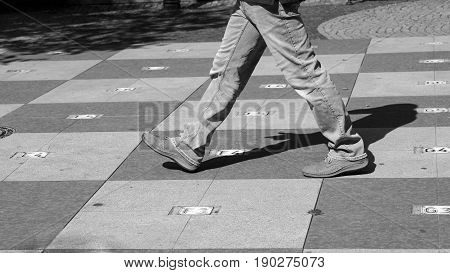 Big chess on the square walking man in the city
