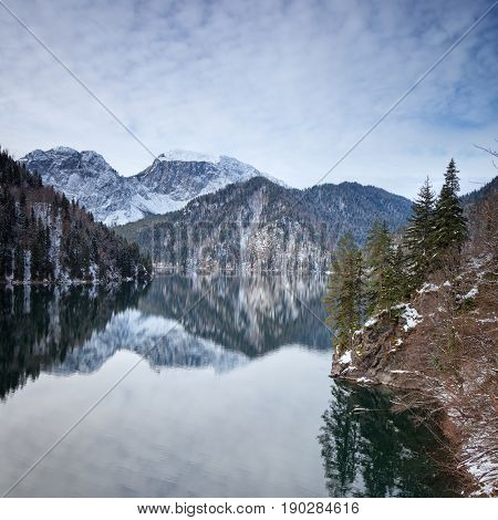 Mountain lake against the backdrop of snow-capped mountains. Rizza Abkhazia