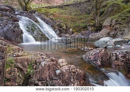 One of a series of waterfalls on Stickle Ghyll in the English Lake District cascading into a clear pool during spring time. A popular tourist path it is a short car journey from Ambleside.