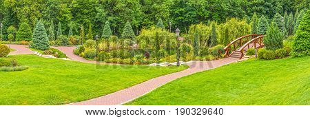 Panorama of the fragment of the park with a lake and a bridge across the river in Mezhyhiria near Kiev.