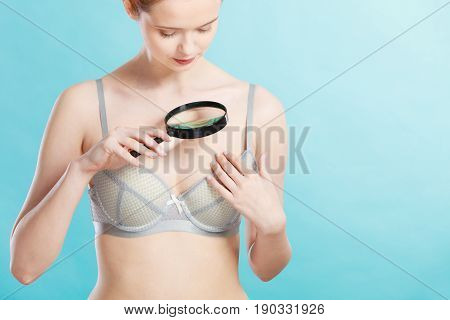 Woman Using Magnifying Glass To Examine Her Moles Skin