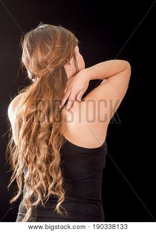 Beautiful young lady Suffer crick after workout in a black background.
