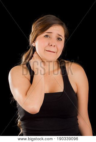Beautiful young lady Suffer crick after workout in a black background.