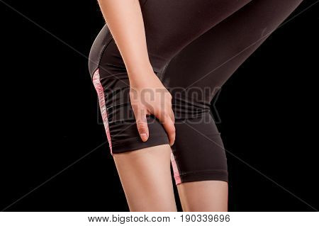 Running sport injury woman athlete joggermassaging calf muscle before workout in black background.