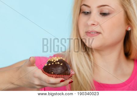 Woman Holding Chocolate Cupcake About To Bite