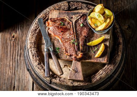 Well Done Tbone Steak And Chips On Old Barrel