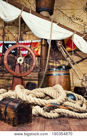 Pirates ship deck with steering wheel and flag.