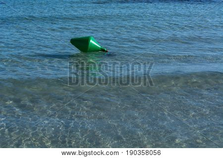 Green buoy as a shipping sign or sea sign in the sea.