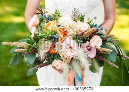 Bride holding big wedding bouquet with roses, peonies, eustoms , closeup