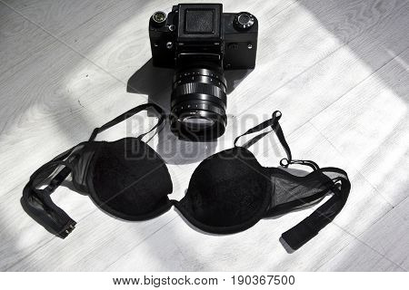 Retro camera with female lace bra top view. Handmade lingerie