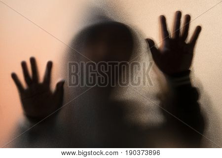 Shadow Blur Of Horror Man In Jacket With Hood.hands On The Glass.dangerous Man Behind The Frosted Gl