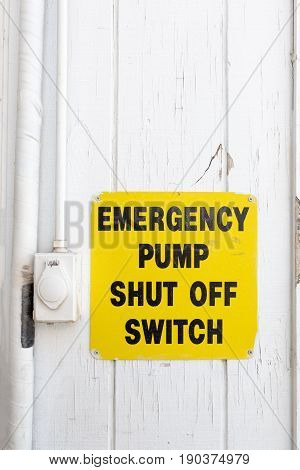 Emergency pump shut off or stop push button switch sign on wood board