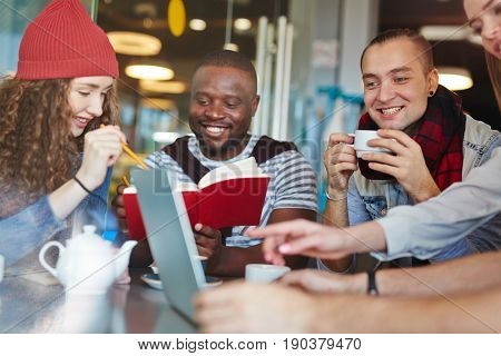 Talented young designers wrapped up in work: they gathered together in lovely coffeehouse and brainstorming on joint project