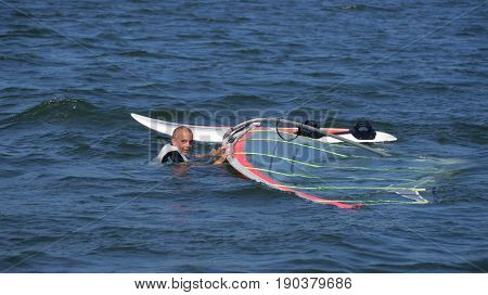 Windsurfing, man in the water at the board, on the lake Niesłysz Polish