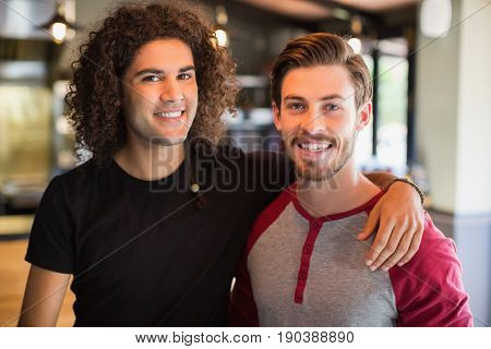 Portrait of smiling young male friends in restaurant