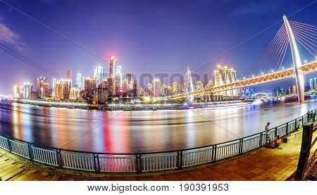 cityscape and skyline of downtown near water of chongqing at night