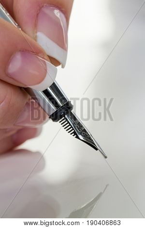 hand with fountain pen signing contract