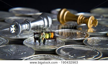 Silver chessboard silver and gold chess silver coins with black background homeless sitting on the bank