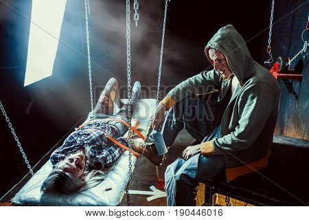 Maniac With The Blade Is Looking At The Tied Victim.