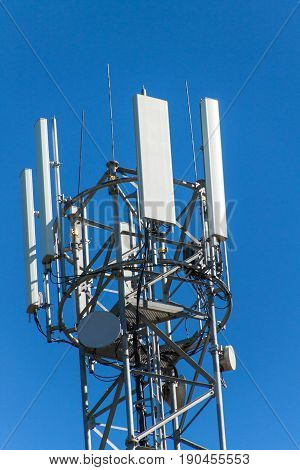 Technology on the top of the telecommunication GSM. Masts for mobile phone signal. Tower with antennas of cellular communication on the background of blue sky.