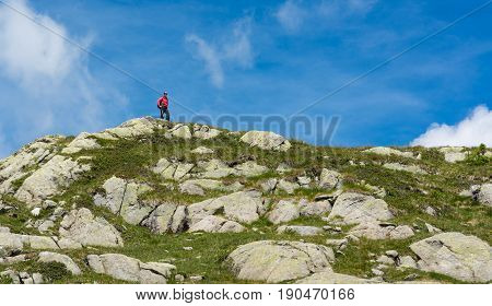 Trekker walking along a ridge. Trekking 5 Laghi trek in Brenta Dolomites.