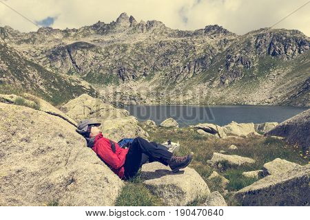 Tired trekker resting near mountain lake. Gelato Laghi, Brenta Dolomites in Italy.