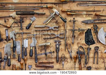 The tools of a tanner hanging on the wall in a tannery.