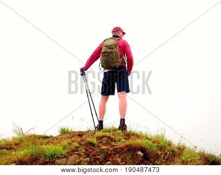 Man In Cloud Of Fog. Hiker In Pink Black Sportswear And Poles