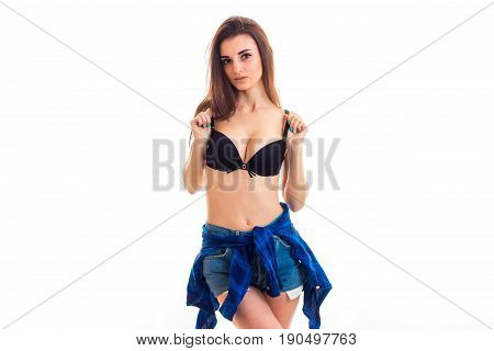 young Sexy brunette in Bra with a beautiful body and large breasts stands in the Studio and posing for the camera isolated on white