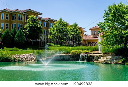 Beautiful waterfall fountian in front of italian style building near park