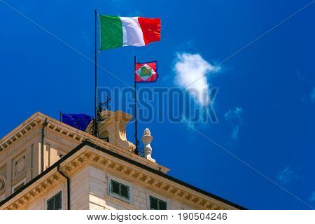 Beautiful large waving the flag of Italy and Italian Presidential pennant over Quirinal Palace against the blue sky, Rome, Italy.