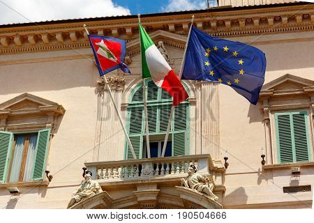 Beautiful large waving Flag of the European Union, Flag of Italy and Italian Presidential pennant on the balcony of the Quirinal Palace, Rome, Italy.