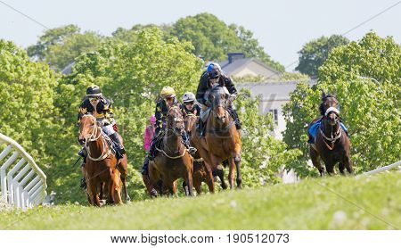 STOCKHOLM SWEDEN - JUNE 06 2017: Fight between jockeys riding arabian race horses in a trees in the background at Nationaldags Galoppen at Gardet. June 6 2017 in Stockholm Sweden