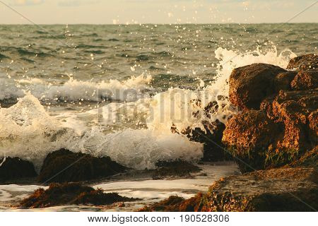 sea sprays on a cliff at the sunset