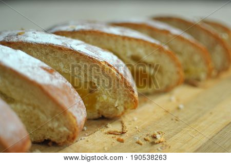 Cut pineapple pie with slices on a stripped cutting board. Close up