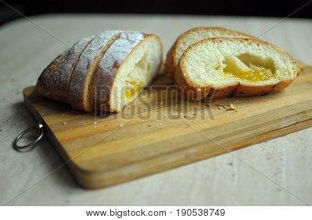 Cut pineapple pie with slices on a stripped cutting board