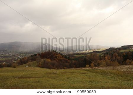 Foggy hills and field with cloudy sky in Poland
