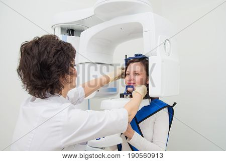 A young dentist taking a panoramic digital X-ray of a patient s teeth