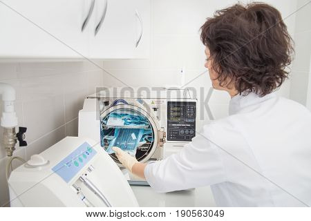 Denatal assistant using Sterilization systems. Preparation instruments for cleaning.